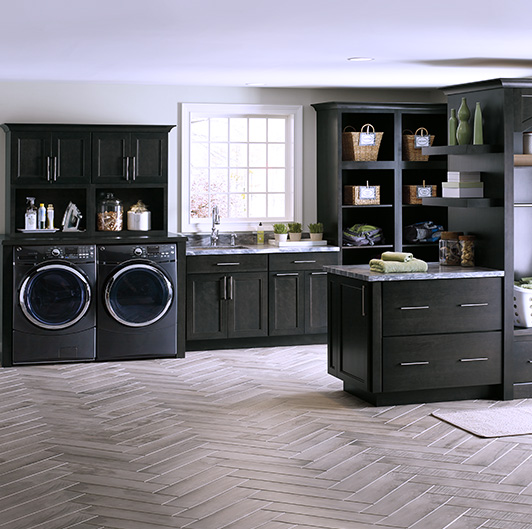 Laundry room with black cabinets and appliances. 