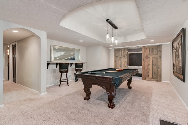 Large finished basement with pool table and bar.