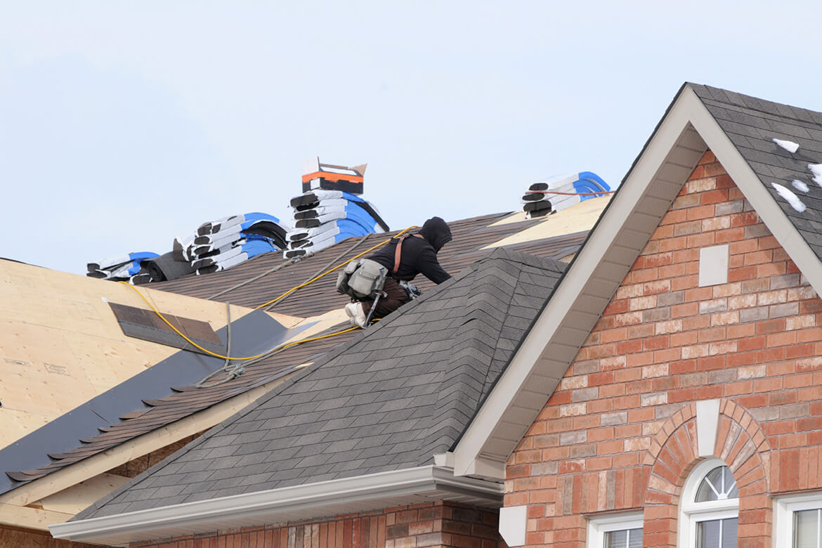 Picture of roofers working on large roof