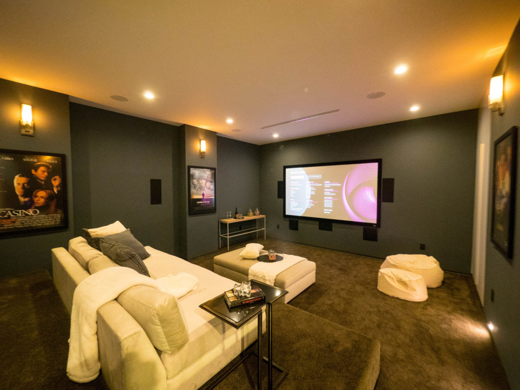 Contemporary basement with dark walls and couches