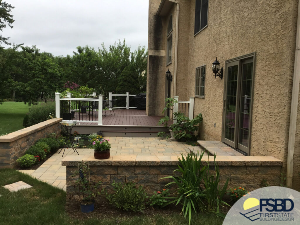 Stone patio with stone wall and composite deck