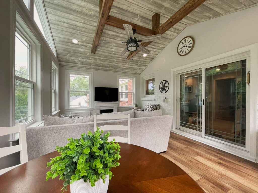 Sunroom interior showing wood beams and plank ceiling